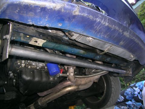1995 Ford Probe - Underside view of a blue vehicle, revealing exhaust system and engine parts, with a 'Supermotors.net' watermark.