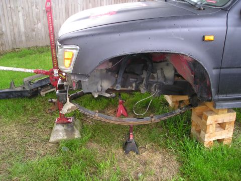 1990 Toyota Pickup/SR5 - The leaf spring has been removed from the vehicle's suspension for repair or replacement.