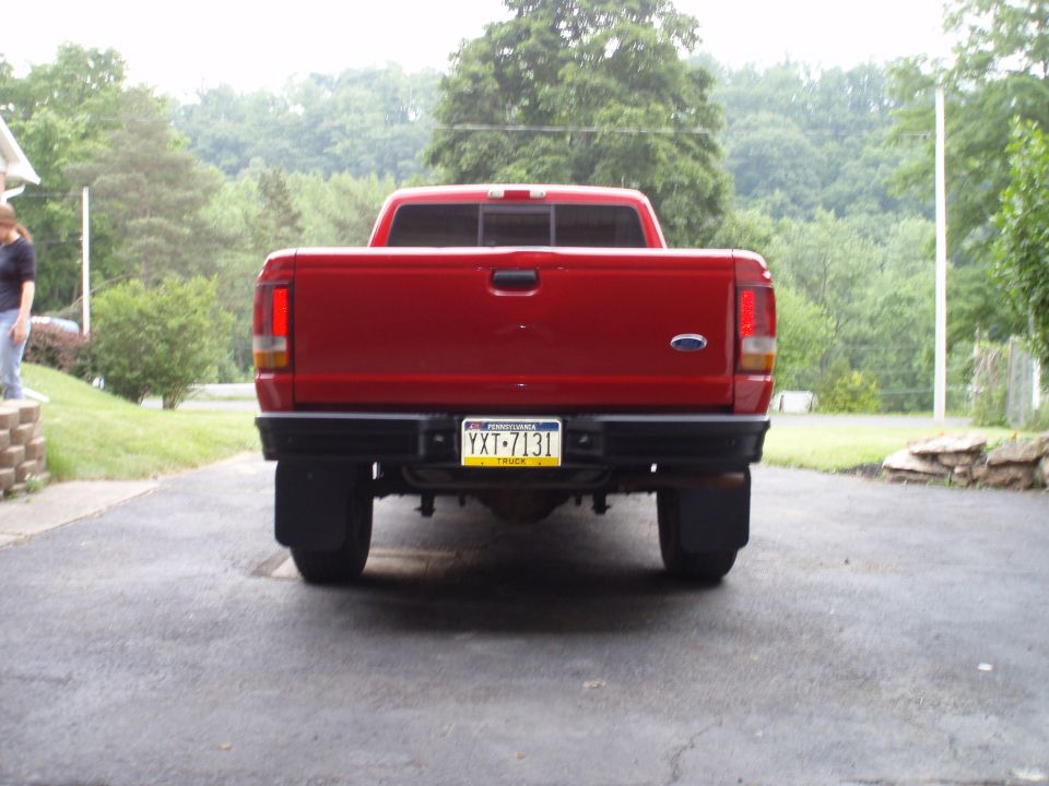 Red 1997 Ford Ranger pickup truck rear view, license plate YXT-7131, with mud flaps