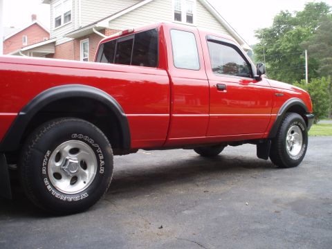 1997 Ford Ranger - Side profile of a red 1997 Ford Ranger pickup truck parked on asphalt.