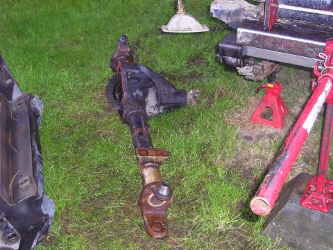 1990 Toyota Pickup/SR5 - Front differential and axle assembly removed from a vehicle, resting on grass with tools nearby.