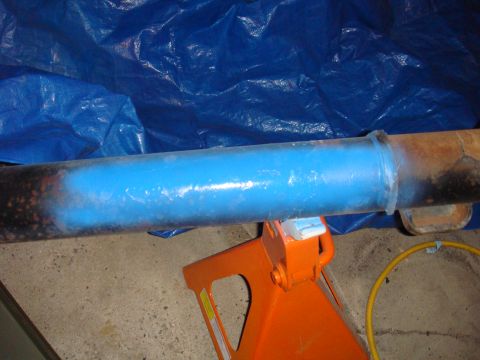 1992 Ford Bronco - Axle housing painted blue and resting on jack stands, with a blue tarp behind it.
