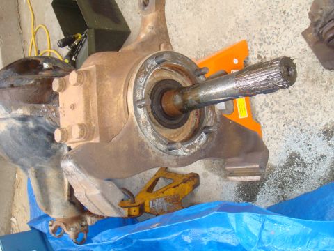 1992 Ford Bronco - A disassembled front axle assembly rests on a blue tarp, awaiting repair or replacement.
