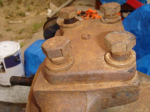 1992 Ford Bronco - This rusty metal part, likely from a vehicle's axle, is covered in dust and has visible bolts and partially obscured bolts.