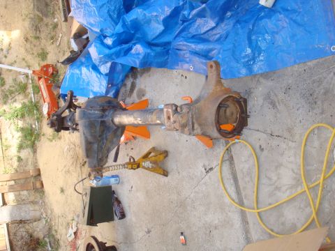 1992 Ford Bronco - A vehicle axle assembly is shown supported by jack stands, with a blue tarp and various tools nearby.