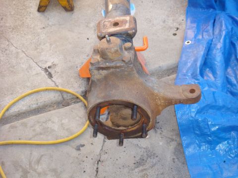 1992 Ford Bronco - Axle housing part shown on jack stands with a yellow hose nearby.