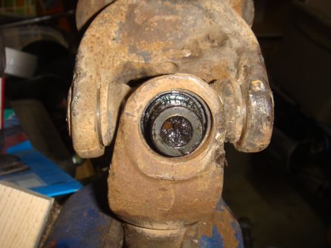 1992 Ford Bronco - Close-up view of a heavily rusted universal joint, showing wear and grease within the bearing cap.