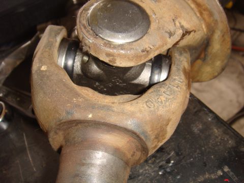 1992 Ford Bronco - Close-up of a corroded universal joint, showing mechanical components and stamped markings.