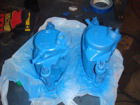 1992 Ford Bronco - Two freshly painted blue brake calipers are laid out on a plastic sheet, ready for installation.