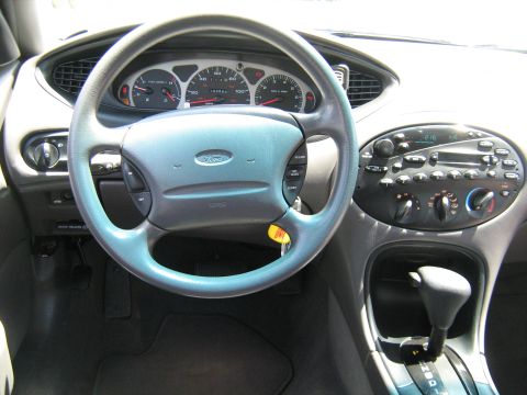 1988 Mercury Grand Marquis - The interior of a car, a Ford steering wheel and dashboard with visible gauges and radio controls.