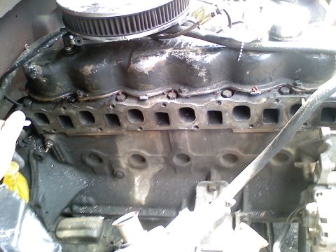 1981 Ford Bronco - Close-up of an inline six-cylinder engine in the vehicle with the exhaust manifold removed, exposing the row of intake and exhaust ports on…