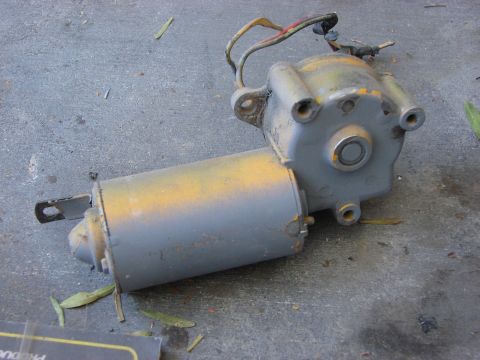 1978 Ford Bronco - This is a close-up view of a used electric motor, possibly for a vehicle component, resting on a gray concrete floor.