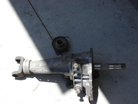 1978 Ford Bronco - A vehicle transfer case and part of a driveshaft are laid out on a concrete surface.