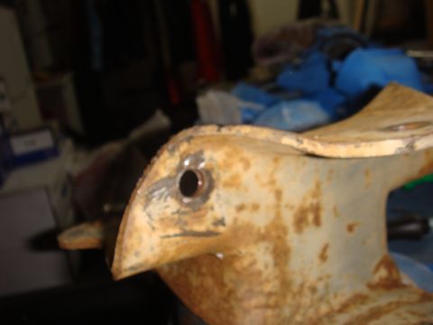 1992 Ford Bronco - Close-up of a rusty metal bracket, possibly a vehicle part, with a visible bolt hole and a Supermotors.net watermark.
