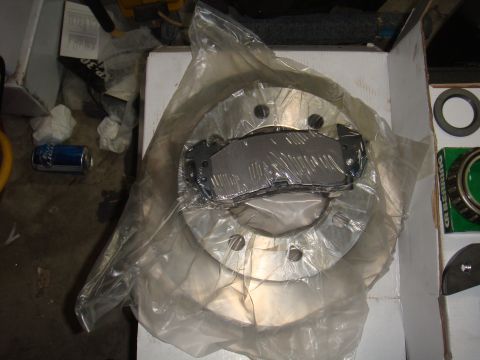 1992 Ford Bronco - New brake rotor and pads are shown packaged for sale.