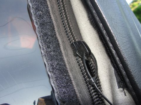 1995 Ford Bronco - A close-up view shows the zipper and velcro closure system on a vehicle's soft top.