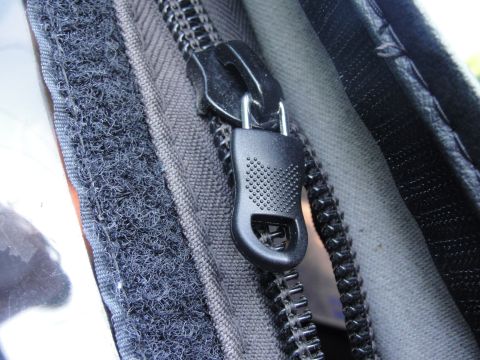 1995 Ford Bronco - Close-up view of a zipper and velcro fastener on a dark fabric material.