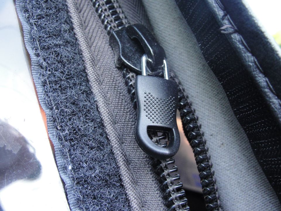 Zipper pull and hook-and-loop fastener on dark fabric