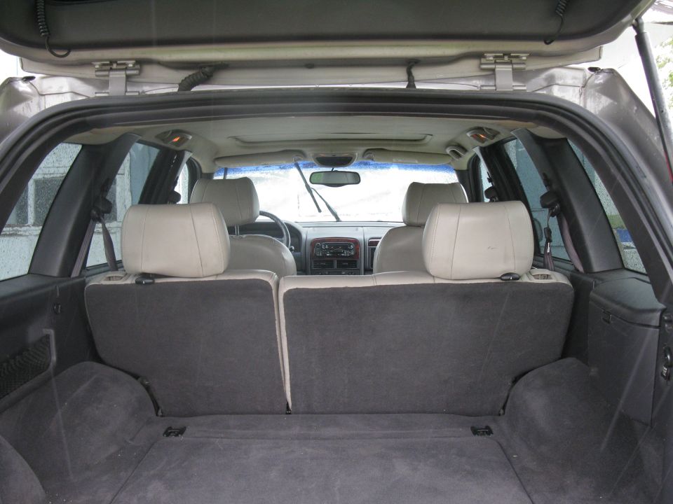 Rear cargo area and back seats of a 2001 Jeep Grand Cherokee. View from the open tailgate looking forward