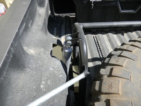 1997 Ford Ranger - A shock absorber is visible in the bed of a truck, near a large tire and a roll bar.