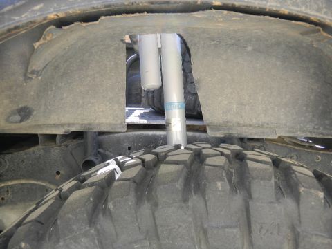 1997 Ford Ranger - Close-up view of a shock absorber and tire tread within a vehicle's wheel well.