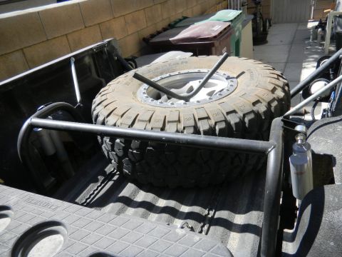 1997 Ford Ranger - A large spare tire is mounted in the bed of a truck, held in place by a roll cage.