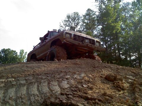 1979 Ford Bronco - This vehicle is covered in mud as it navigates a steep, muddy incline.