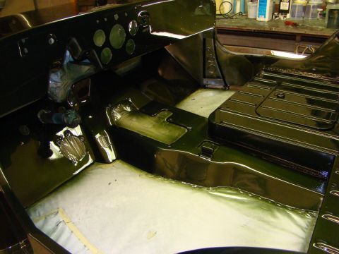 1948 Jeep Wrangler - The interior of a dark green vehicle, possibly a Jeep, is shown during a restoration process, with the dashboard and floor area visible.