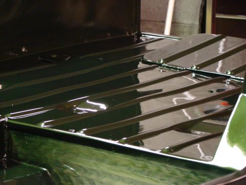 1948 Jeep Wrangler - The ribbed flooring of a green vehicle bed is visible, with a metal panel on the right.
