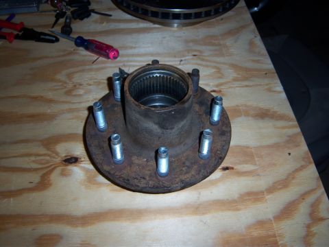 1996 Ford Bronco - Wheel hub assembly with lug bolts, likely for a truck or SUV, resting on a workbench.
