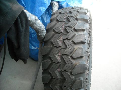 1985 Ford Bronco - A close-up view of a tire with aggressive tread patterns, suggesting off-road capability.
