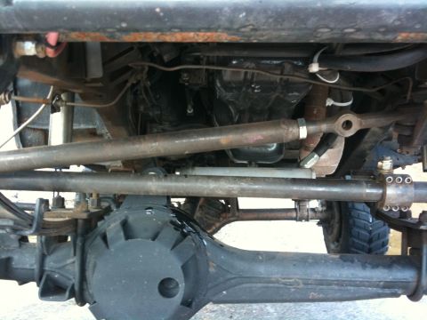 1987 Suzuki Samurai - Close-up view of the undercarriage and suspension system of an off-road vehicle.