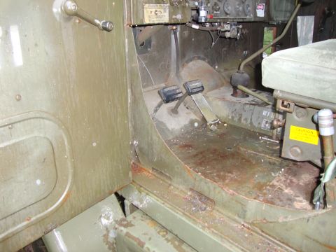 1970 Jeep Commando - The interior of a utilitarian vehicle displays floor pedals and a transmission shifter, with visible signs of wear and rust.