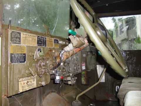1970 Jeep Commando - The interior of a military truck shows a complex dashboard with numerous gauges and controls, along with a large steering wheel.