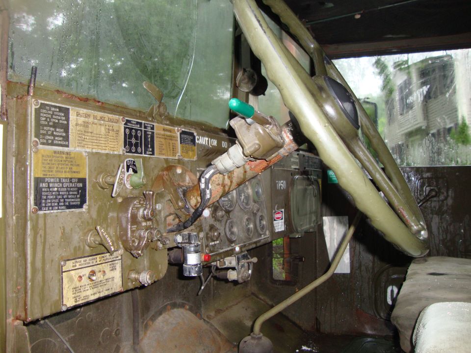 Military truck interior with dashboard gauges, levers, and steering wheel