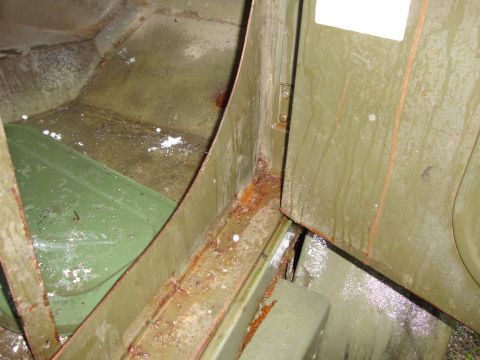 1970 Jeep Commando - The interior floor and door jamb show significant rust and water damage, indicating poor condition.