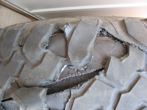 1995 Ford Bronco - This tire has sustained significant damage, exposing the internal cords.