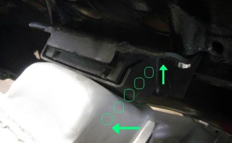 1985 Ford Bronco - Close-up view of an engine mount bracket, highlighting mounting points with green arrows.