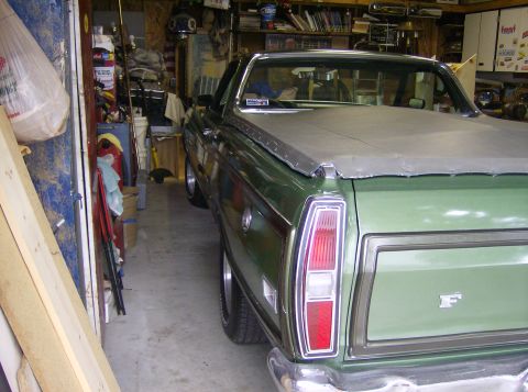 1970 Ford Ranchero - Rear view of a green 1970 Ford Ranchero with a tonneau cover, parked indoors.