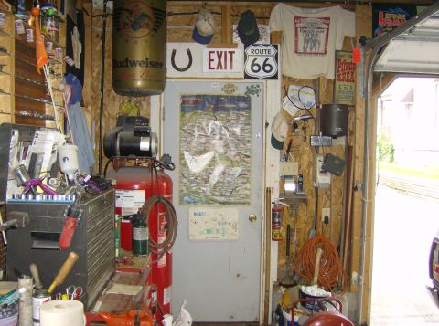 1970 Ford Ranchero - A cluttered garage scene features an air compressor, tool chest, and various wall decorations including Budweiser and Route 66 signs.
