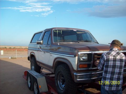 1985 Ford Bronco - This 1985 Ford Bronco is on a trailer, with a person looking at the front grille.