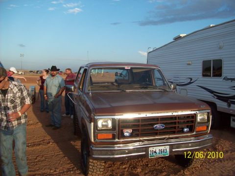 1985 Ford Bronco - This 1980s Ford Bronco is seen from the front, parked next to a trailer.