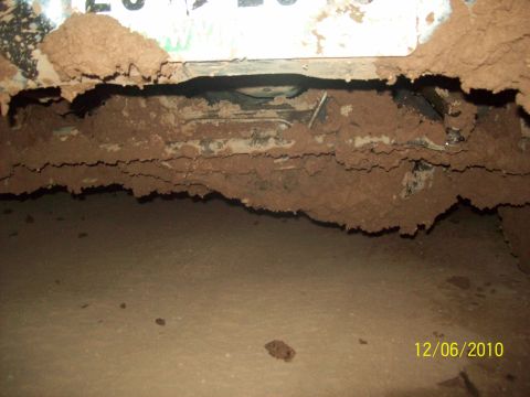 1985 Ford Bronco - Mud buildup on the undercarriage of a vehicle.