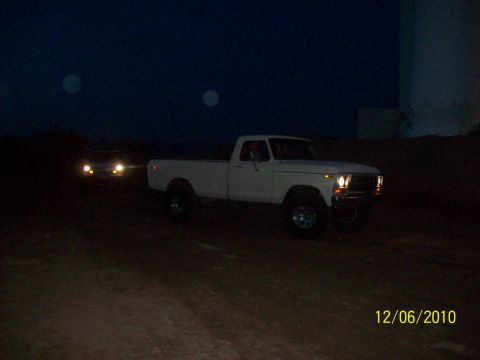 1985 Ford Bronco - A white 1979 Ford F-150 pickup truck is seen at night, with another vehicle approaching in the background.