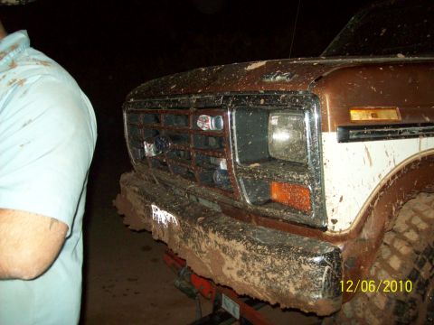 1985 Ford Bronco - Front view of a mud-caked Ford truck, likely from the early 1980s, after off-road use.