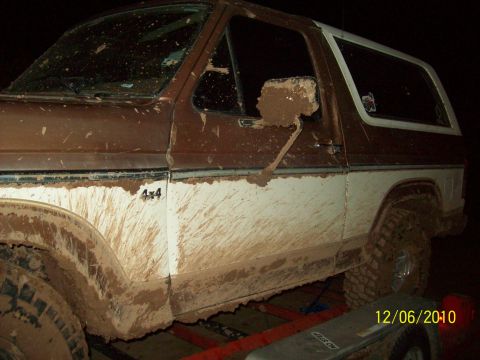 1985 Ford Bronco - This SUV is heavily covered in mud, obscuring its exact model year and details.