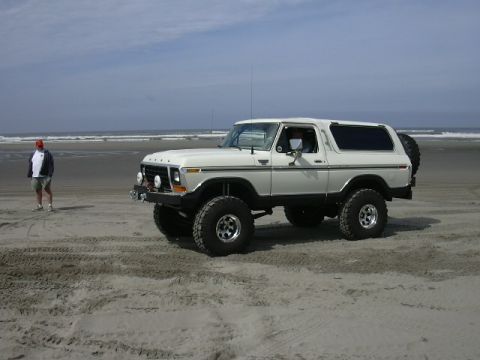 1991 Ford Bronco - A lifted 1978 Ford Bronco sits on a sandy beach with the ocean waves in the distance.