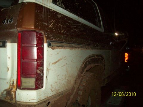 1985 Ford Bronco - This 1985 Ford Bronco is covered in mud, showing its rear quarter panel and 4x4 badging.