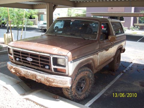 1985 Ford Bronco - This Ford Bronco is heavily coated in mud, suggesting recent off-road use.