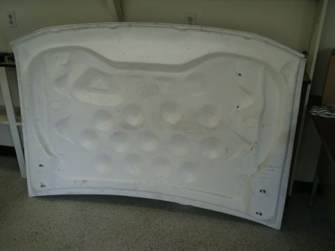 1990 Ford Bronco - The underside of a car hood is shown, revealing its internal structure and reinforcement.